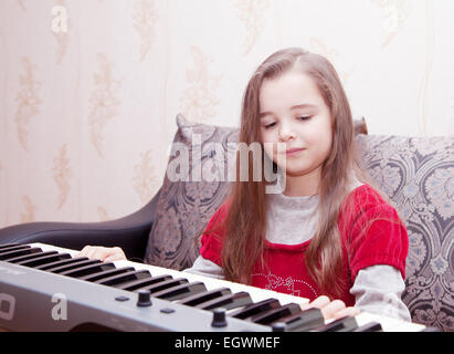 girl playing on a synthesizer Stock Photo