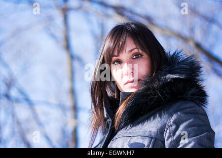 Portrait of a pretty woman posing in the woods in winter Stock Photo