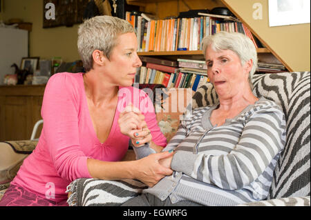 A daughter looking after her mother who is suffering from Alzeimer's. Stock Photo