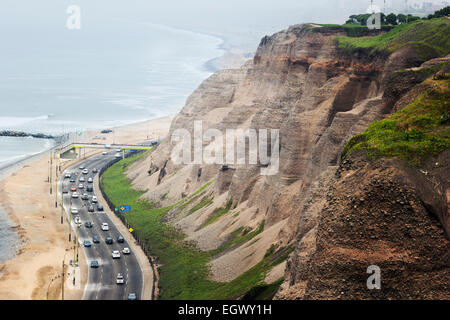 Cars on a busy road next to the hills in Miraflores in Lima Stock Photo