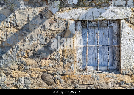 Ruined stone wall and window of an old abandoned house Stock Photo
