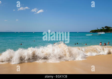 Holidaymakers and locals swimming in Atlantic ocean waves in holiday resort of Sosua, Dominican Republic, Caribbean Islands Stock Photo