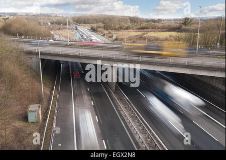 Free flowing motorway traffic at dual carriageway junction flyover bridge with lorries cars moving fast leaving trails as move Stock Photo