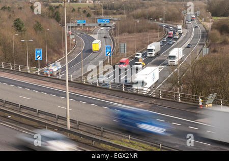 Free flowing motorway traffic at dual carriageway junction flyover bridge with lorries cars moving fast leaving trails as move Stock Photo