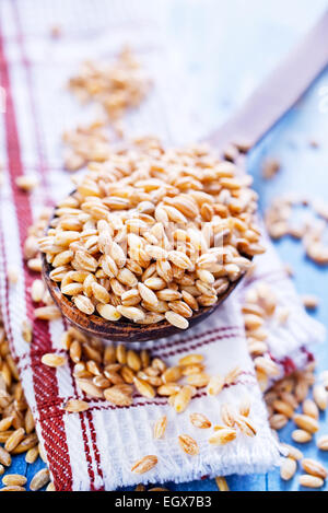 wheat in wooden spoon and on a table Stock Photo