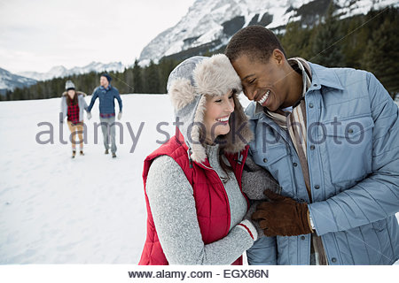 Couple hugging and smiling in snowy field