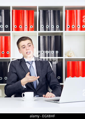 confident young businessman working on laptop in his office Stock Photo