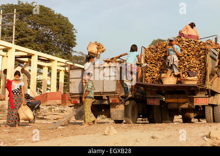 Children loading a lorry with wood - example of child labour; the banks of the Irrawaddy river, Mandalay, Myanmar ( Burma ) Asia Stock Photo