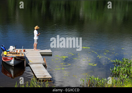 Fisherman with fishing rods is fishing in a wooden boat against background  of beautiful nature and lake or river. Camping tourism relax trip active li  Stock Photo - Alamy