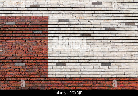 White and orange red brick wall with  irregular surface interspersed with some gray bricks Stock Photo