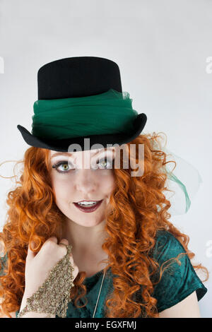 Close-up of pretty young woman with long, curly hair and tophat with green tulle Stock Photo