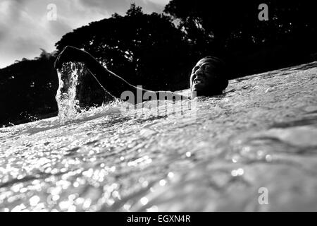 A Colombian sand miner dives under the water to extract sand from the bottom of the river La Vieja in Cartago, Colombia. Stock Photo