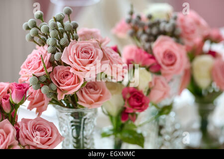 Bouquets of roses on a festive wedding table in the restaurant. Stock Photo