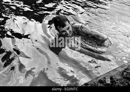 A Colombian sand miner dives under the water to extract sand from the bottom of the river La Vieja in Cartago, Colombia. Stock Photo