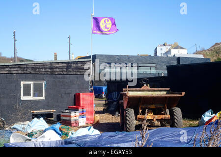 UKIP Flag flying over Fishing huts on Hastings Stade beach by the Jerwood Gallery  East Sussex England GB UK Stock Photo