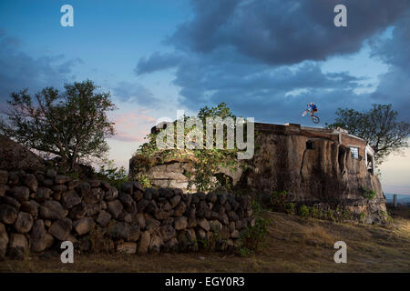 A bike rider performs on a rocky field in Mexico Stock Photo