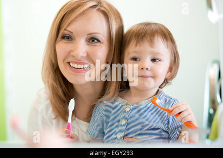 Hygiene. Happy mother and child brushing teeth together Stock Photo