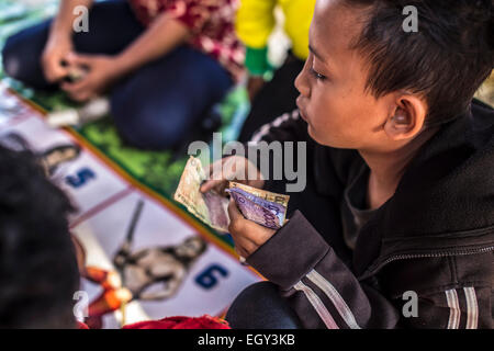 It's happens during a large village festivals.  Adults and children gamble with the cash rate.  This is despite the fact that Indonesia is a Muslim country, and gambling is prohibited here. Stock Photo