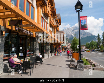 People sitting outside a cafe on Banff Avenue in Banff Alberta Canada Stock Photo