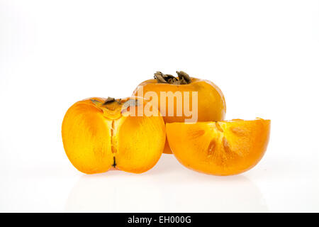 Persimmons, one whole and one cut in two pieces isolated on a white background Stock Photo