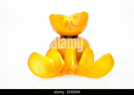 Persimmons, one whole and one cut in two pieces isolated on a white background Stock Photo