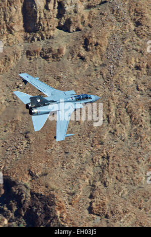 Royal Air Force Tornado GR4 Jet Fighter Flying At Low Level Through A Desert Valley. Stock Photo