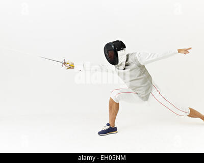 a male fencer attacking opponent. Stock Photo