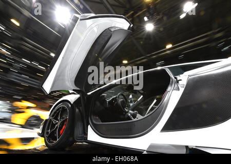 Geneva, Switzerland. 4th Mar, 2015. The new MC Laren 675 LT is displayed on a rotating platform at the Palexpo fairground a day prior to the official opening of the 85th Geneva International Motor Show in Geneva, Switzerland, 4 March 2015. The 85th Geneva International Motor Show runs from 05 until 15 March 2015. The background is blurry due to long exposure. Photo: Felix Kaestle/dpa/Alamy Live News Stock Photo