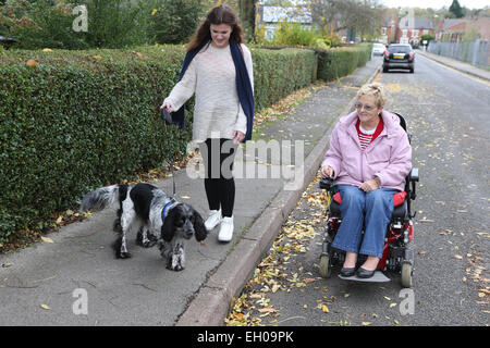 Young girl and wheelchair user talking dog for walk - model released Stock Photo