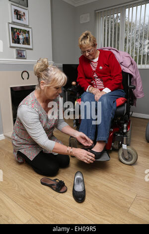 Carer putting Wheelchair user's shoes - model released Stock Photo