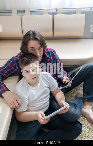 dad and son   with tablet computer indoor Stock Photo