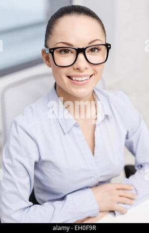 smiling businesswoman in eyeglasses in office Stock Photo