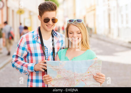 smiling couple with map and photo camera in city Stock Photo