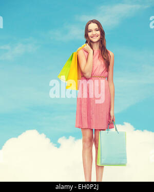 smiling woman in dress with many shopping bags Stock Photo