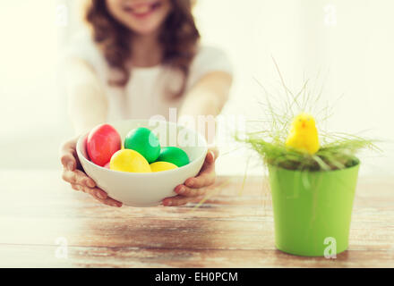 close up of girl holding bowl with colored eggs Stock Photo