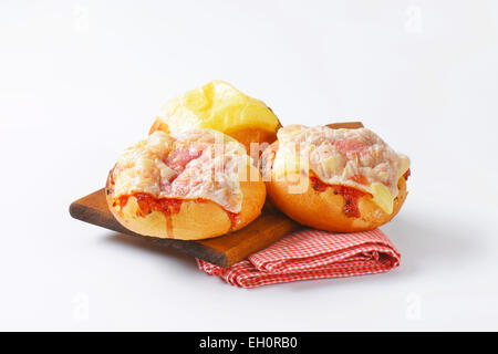 Bread rolls with slices of cheese and ham on top Stock Photo