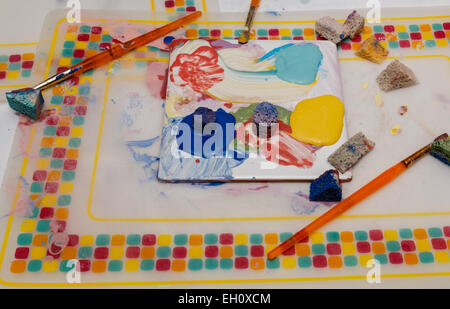 An artists mixing palette with ceramic paint sponges, brushes and paint for mixing Stock Photo