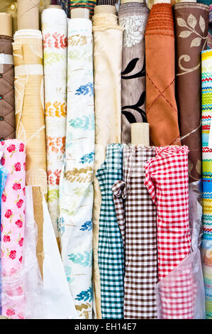 Colorful rolls of patterned fabric on sale at a market Stock Photo