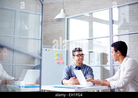 Two young businessmen sharing ideas or discussing project Stock Photo