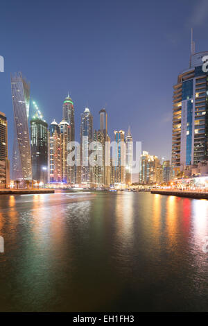 UAE, Dubai, city skyline with the iconic twisted 'Cayman Tower' and Dubai Marina at night. Stock Photo