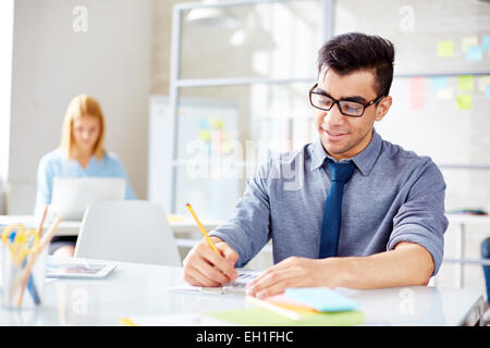 Happy businessman working with document on background of his colleague Stock Photo