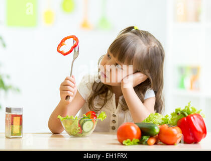 Cute little girl not wanting to eat healthy food Stock Photo