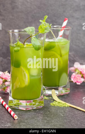 Matcha Mint Iced Tea. Healthy Iced Matcha Tea with lime, ginger and mint with matcha powder on side. Macro, selective focus Stock Photo
