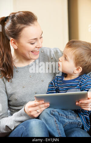 Mother And Son Playing On Digital Tablet Together Stock Photo