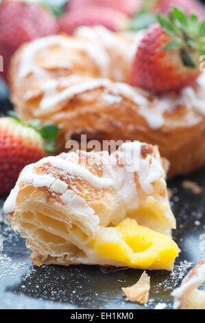Vanilla cream filled danish pastry with frosting. Stock Photo