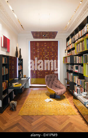 Armchair and bookcases in residential study, UK Stock Photo