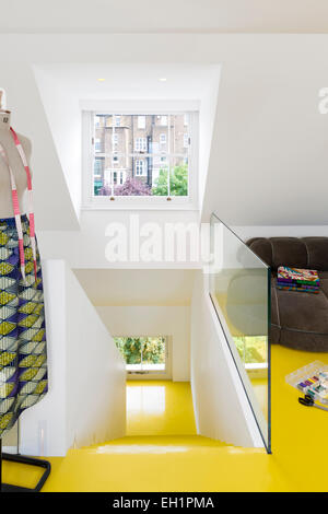 Yellow laminate flooring and staircase in open plan UK home Stock Photo