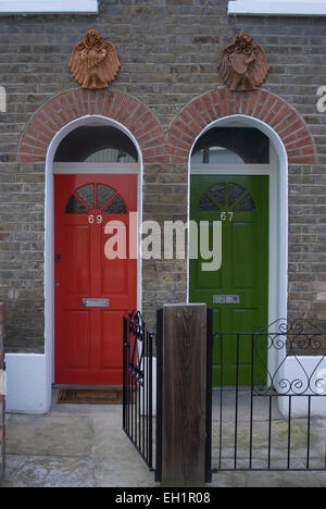 Red and green doors of two adjoining flats in a terrace house, Greenwich, SE10, London, UK