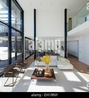 Large, white, open plan modernist room with kitchen, dining and seating area in private home in Westend, Espoo, Finland Stock Photo