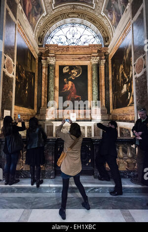 Rome. Italy. Visitors admiring the work of Caravaggio in the Contarelli Chapel, Chiesa di San Luigi dei Francesi. Stock Photo